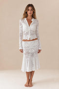 Front view of woman wearing white crochet lace cardigan and midi skirt set
