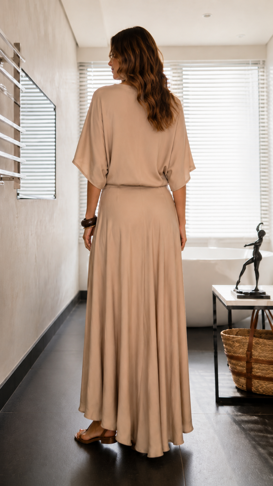 Back view of beige maxi dress with relaxed batwing sleeves and flowing skirt